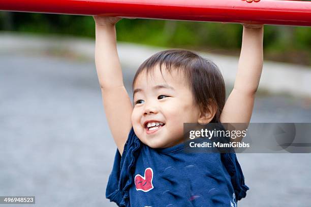 little girl is playing on the horizontal bar - horizontal bar stock pictures, royalty-free photos & images