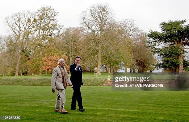 British Prime Minister David Cameron walks with Indian Prime Minister Narendra Modi in the garden at Chequers, the prime minister's official country...