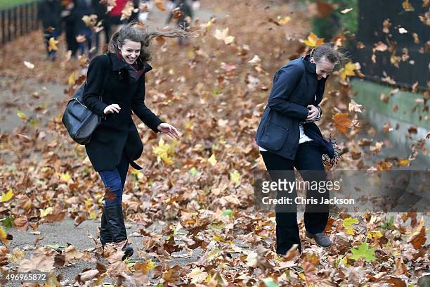 Two women get caught in gusts of wind during a rain storm in Green Park on November 13, 2015 in London, England.