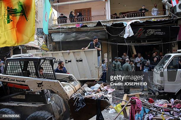 Lebanese municipality workers clear debris from the site of a twin bombing attack in the area of Burj al-Barajneh in Beirut's southern suburb on...