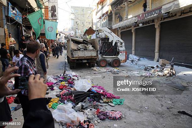 Lebanese municipality workers clear debris from the site of a twin bombing attack in the area of Burj al-Barajneh in Beirut's southern suburb on...