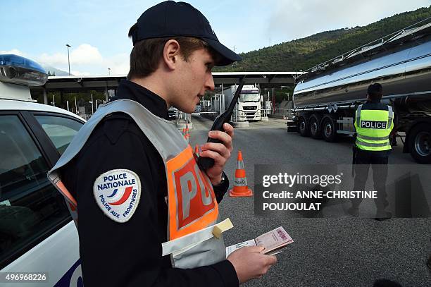 French border police officer controls passports on the A8 motorway at La Turbie toll near the French-Italian border on November 13, 2015. 30,000...