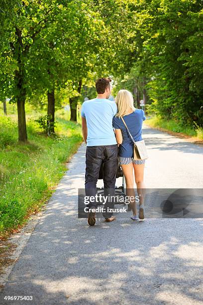 couple walking in a park - woman pram stock pictures, royalty-free photos & images
