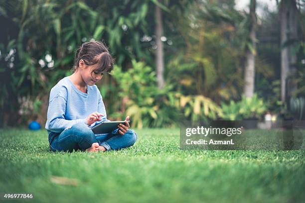 rading on digital tablet - kid sitting stock pictures, royalty-free photos & images