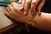 Adult female wearing a gold charm bracelet