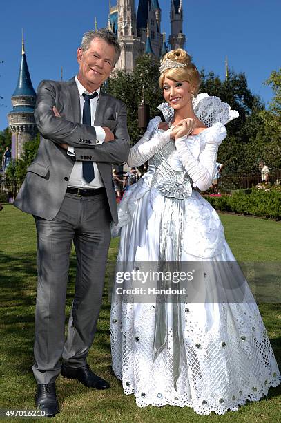 In this handout provided by Disney Parks, David Foster poses with Cinderella during a break from taping the 'Disney Parks Unforgettable Christmas...