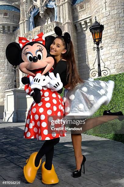 In this handout provided by Disney Parks, Ariana Grande poses with Minnie Mouse during a break from taping the 'Disney Parks Unforgettable Christmas...