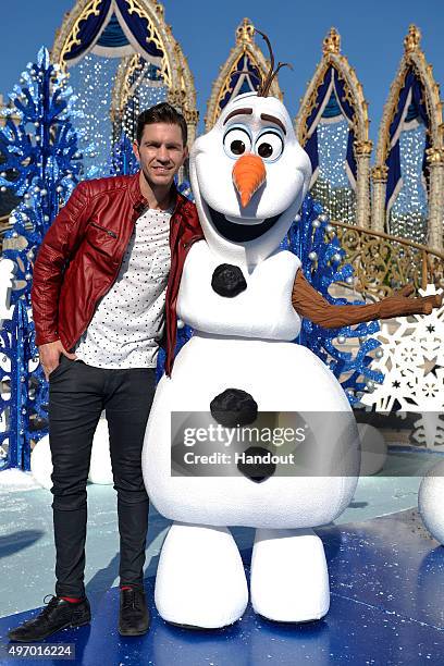 In this handout provided by Disney Parks, Andy Grammer poses with Olaf from Disneys "Frozen" during a break from taping the 'Disney Parks...