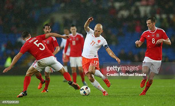 Arjen Robben of Netherlands is challenged by James Chester and Andy King during the international friendly match between Wales and Netherlands at...