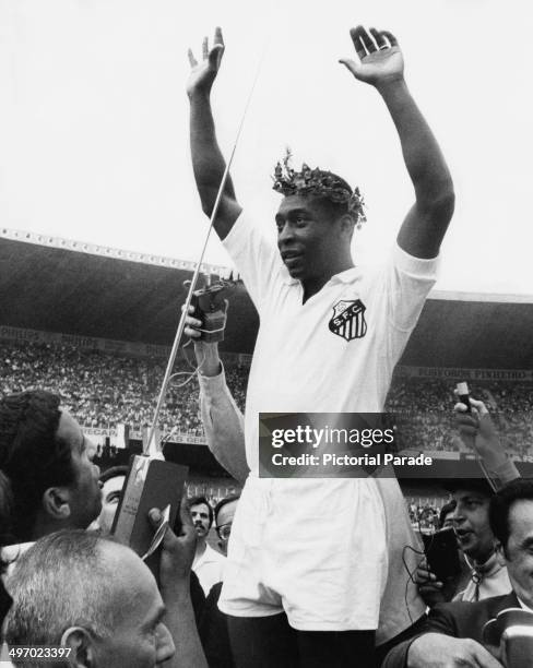 Brazilian footballer Pele wearing a wreath while celebrating with his team Santos FC, 24th November 1969.