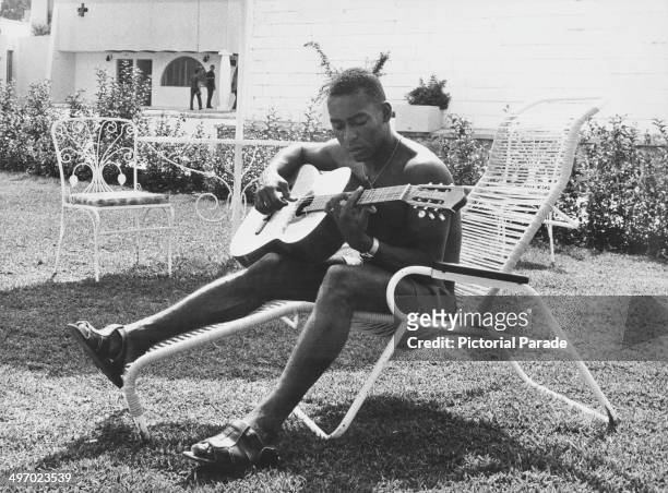 Brazilian footballer Pele relaxing with his guitar during the World Cup in Mexico, May 1970.
