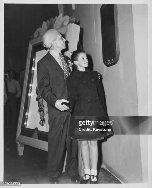 Actress Margaret O'Brien and showman Sid Grauman, looking at the bronze plaque dedicated to her at the 'Hall of Fame', Hollywood, circa 1950.