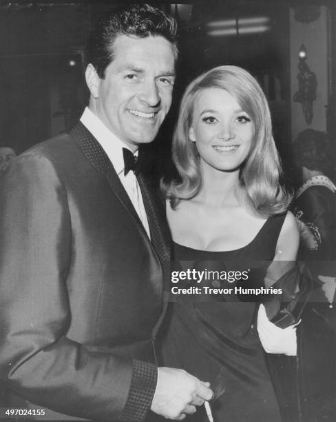 Actors Hugh O'Brian and Barbara Bouchet, arriving at the premiere of the movie 'In Harm's Way', Plaza Cinema, Leicester Square, May 15th 1965.