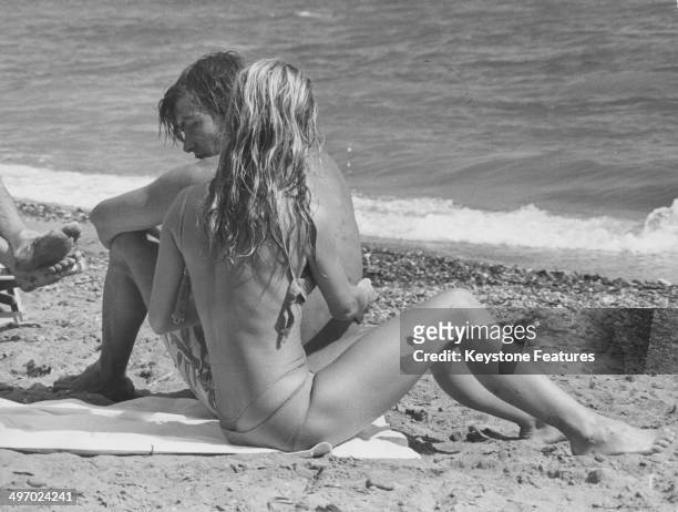 Actress Brigitte Bardot and her partner Patrick Gilles relaxing on a beach, during a break from filming 'Rum Runners', Almeria, Spain, 1970.