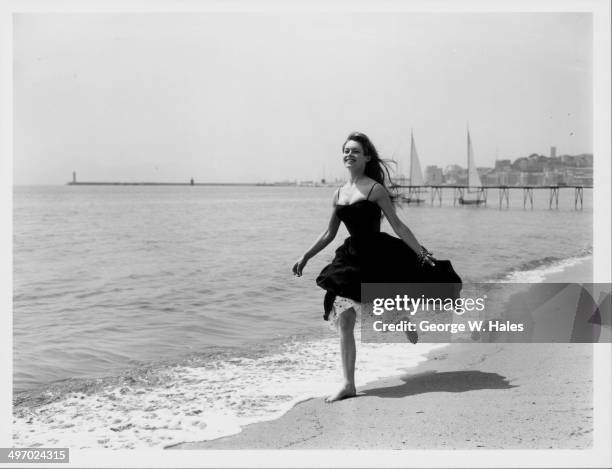 Actress Brigitte Bardot running barefoot along the beach, Cannes, France, April 28th 1956.