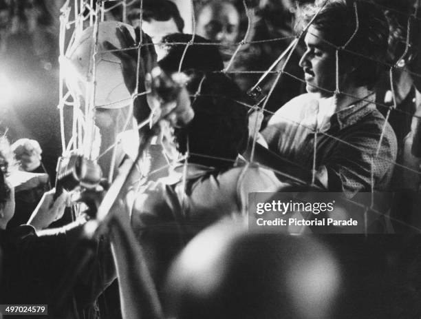 Pele is lost in a goalmouth crowd after scoring the 1,000th goal of his career during a game for Santos FC against Vasco da Gama at the Maracana...