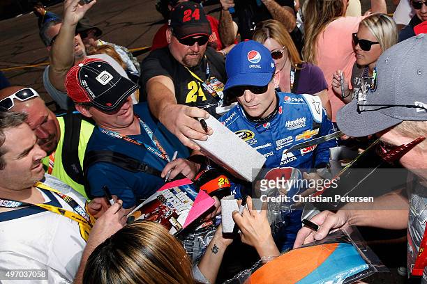 Jeff Gordon, driver of the Pepsi Chevrolet, signs autographs during practice for the NASCAR Sprint Cup Series Quicken Loans Race for Heroes 500 at...