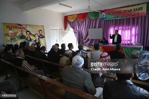 Residents attend a commune meeting at a Mala Gel or People's House on November 13, 2015 in Derek, in autonomous Rojava, Syria. Portraits of Kurdish...