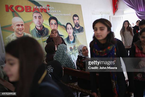 Residents take part in a commune meeting at a Mala Gel or People's House on November 13, 2015 in Derek, in autonomous Rojava, Syria. Portraits of...