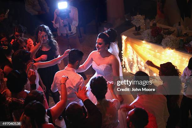 Bride and groom dance with guests at a Christian wedding on November 13, 2015 in Derek, in autonomous Rojava, Syria. Weddings take place almost every...