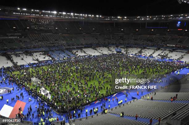 Spectators gather on the pitch of the Stade de France stadium following the friendly football match between France and Germany in Saint-Denis, north...