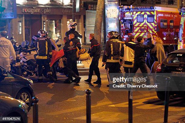Medics move a wounded man near the Boulevard des Filles-du-Calvaire after an attack November 13, 2013 in Paris, France. Gunfire and explosions in...