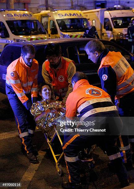 Rescuers evacuate an injured woman on Boulevard des Filles du Calvaire, close to the Bataclan theater, early on November 14, 2015 in Paris, France....