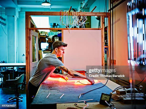 neon artist working on piece in loft - kunsthandwerker stock-fotos und bilder