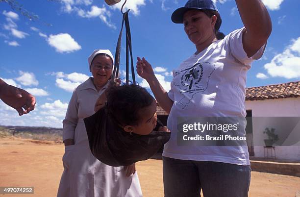 Fight against infant malnutrition - NGO "Pastoral da Criança" agents monitor children´s weight with a scale in the rural area of region affected by...