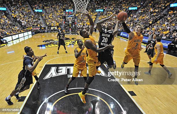 Guard Ron Baker of the Wichita State Shockers blocks the shot of guard Demetrius Pollard of the Charleston Southern Buccaneers during the first half...