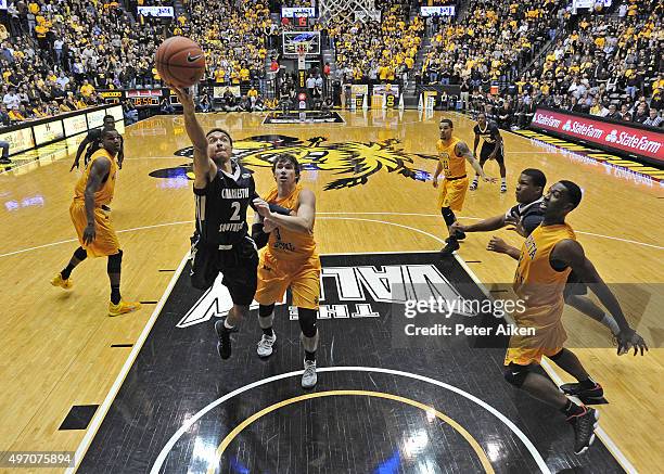 Guard Aaron Wheler of the Charleston Southern Buccaneers drives to the basket against guard Evan Wessel of the Wichita State Shockers during the...