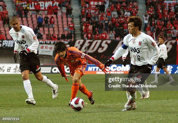 Atomu Tanaka of Albirex Niigata competes against Keisuke Tsuboi and Nobuhisa Yamada of Urawa Red Diamonds during he J.League match between Albirex...