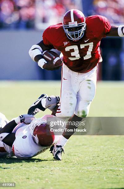 Shaun Alexander of the Alabama Crimson Tide carries the ball as he is grabbed during the game against the Arkansas Razorbacks at the Bryant-Denny...