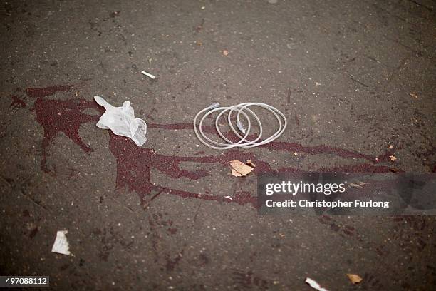 Blood stains mark the pavement where casualties where treated near the scene of the Bataclan Theatre terrorist attack on November 14, 2015 in Paris,...