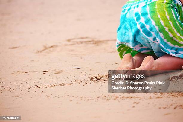 girl with bare feet kneeling in sand - bare feet kneeling girl stock-fotos und bilder