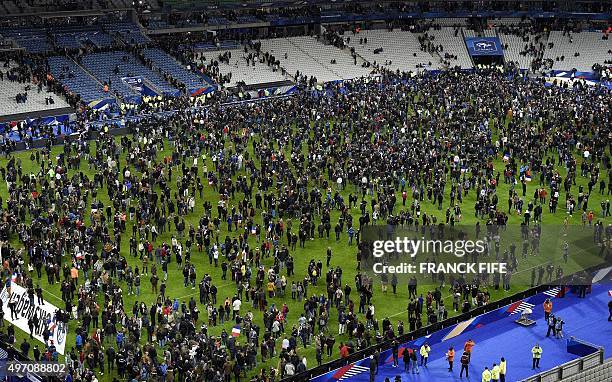 Football fans gather on the field of the Stade de France stadium following the friendly football match between France and Germany in Saint-Denis,...