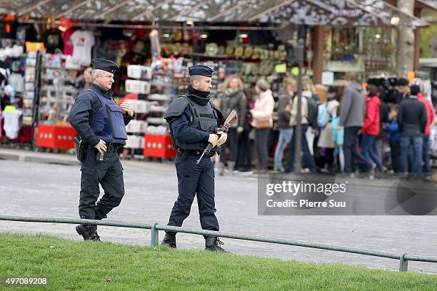 Ambiance outside the Arc De Triomphe as police patrol in front of the Arc De Triomphe on November 14, 2015 in Paris, France. At least 120 people have...