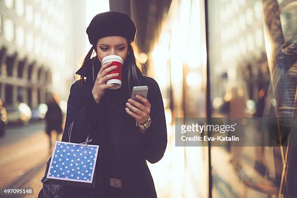 winter shopping saison - winter woman phone stock-fotos und bilder