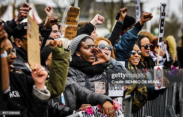 People shoot slogans and hold placards during a demonstration to protest against the racist nature of traditional figure Zwarte Piet , on November...