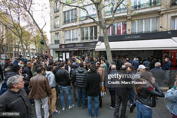 The crowd is seen in front of the 'La Belle Equipe' restaurant the day after the terrorist attack on November 14, 2015 in Paris, France. At least 120...