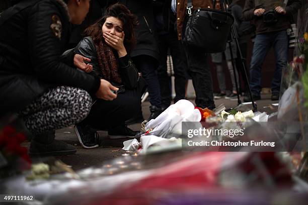 Woman reacts after placing flowers near the scene of yesterday's Bataclan Theatre terrorist attack on November 14, 2015 in Paris, France. At least...