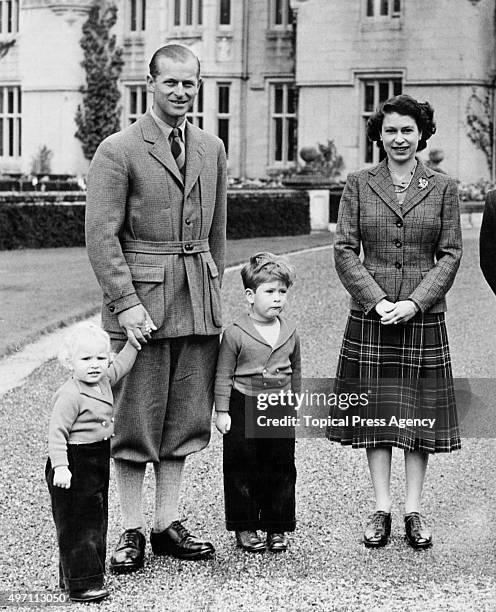 The royal family in the grounds of Balmoral Castle in Scotland, 26th September 1952. From left to right, Princess Anne, the Duke of Edinburgh, Prince...
