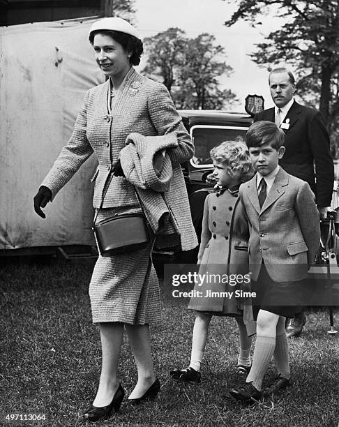 Queen Elizabeth II arrives for the final day of the Windsor Horse Show with her children, Prince Charles and Princess Anne, England, 12th May 1956.