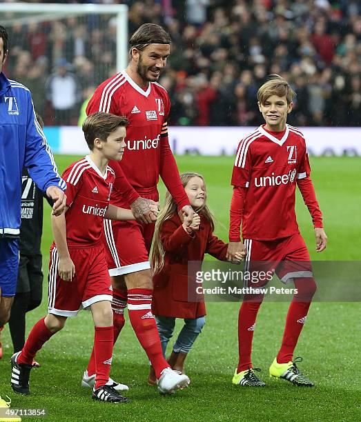 David Beckham of Great Britain and Ireland walks out with his children Cruz, Romeo and Harper ahead of the David Beckham Match for Children in aid of...