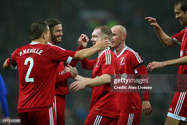 Paul Scholes of Great Britain and Ireland is congratulated by teammates after scoring the opening goal during the David Beckham Match for Children in...