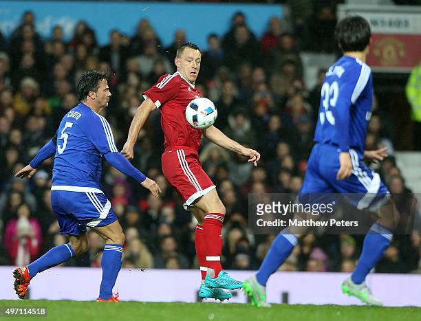 John Terry of Great Britain and Ireland in action with Fernando Couto and Ji-sung Park of Rest of the World during the David Beckham Match for...