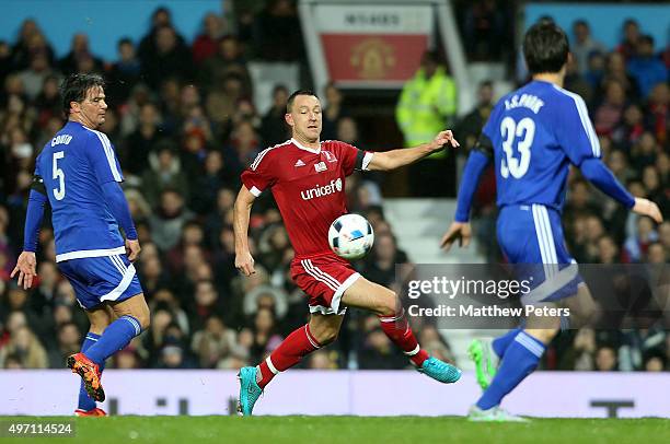 John Terry of Great Britain and Ireland in action with Fernando Couto and Ji-sung Park of Rest of the World during the David Beckham Match for...