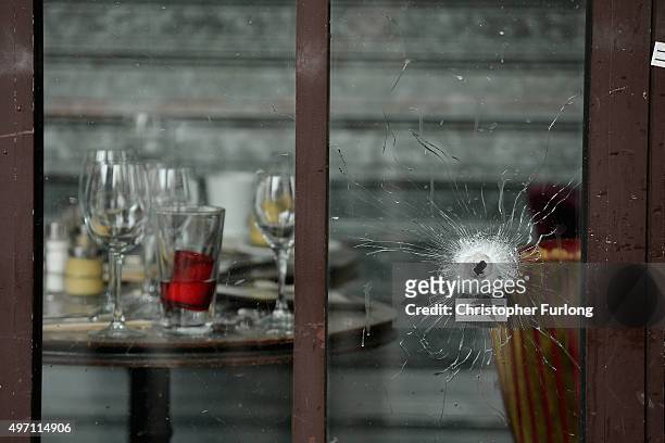 Bullets holes are seen through the glass door of a cafe near Casa Nostra after yesterday's terror attack on November 14, 2015 in Paris, France. At...