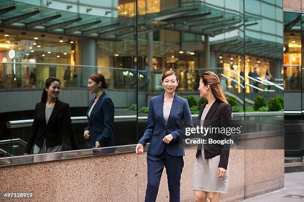 empowered chinese businesswomen walk and talk in hong kong - 2 international finance center stockfoto's en -beelden