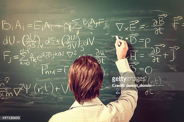 man standing against chalkboard, solves physics equations, rear view, retro - mathematics stock pictures, royalty-free photos & images
